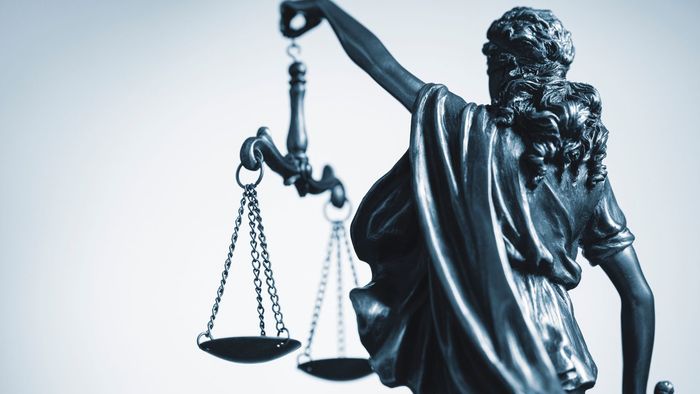 Blindfolded Lady Justice statue holding scales, symbolizing law and justice