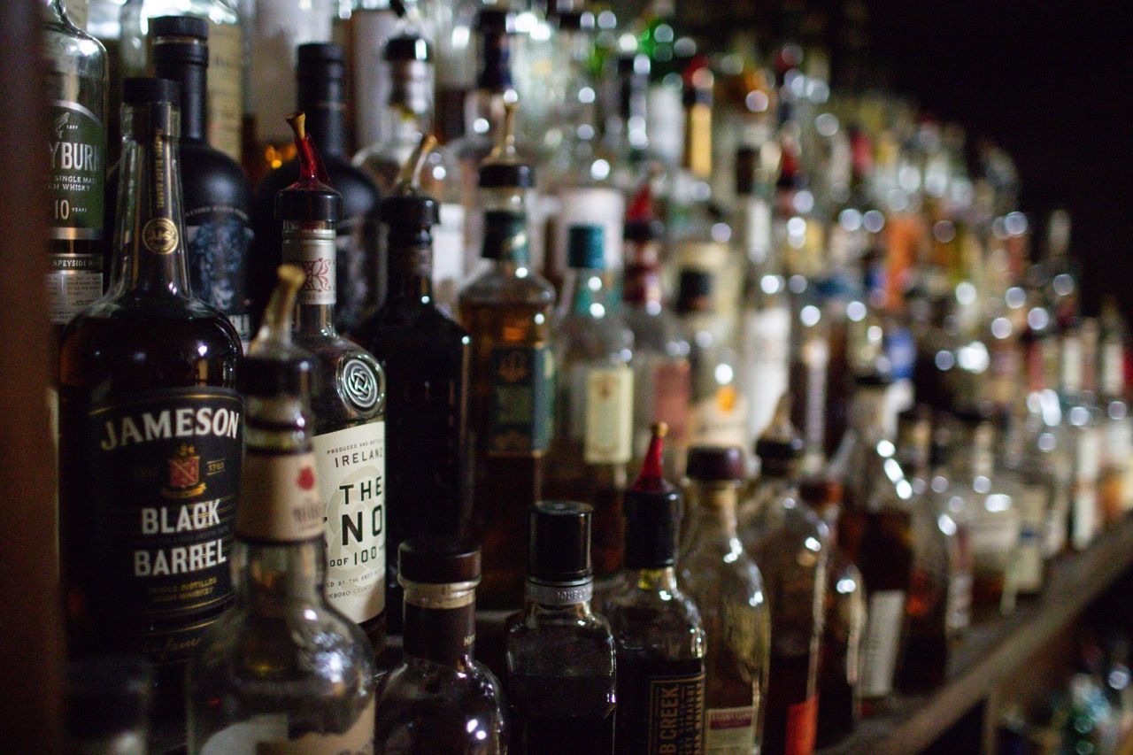 A row of liquor bottles including jameson black barrel