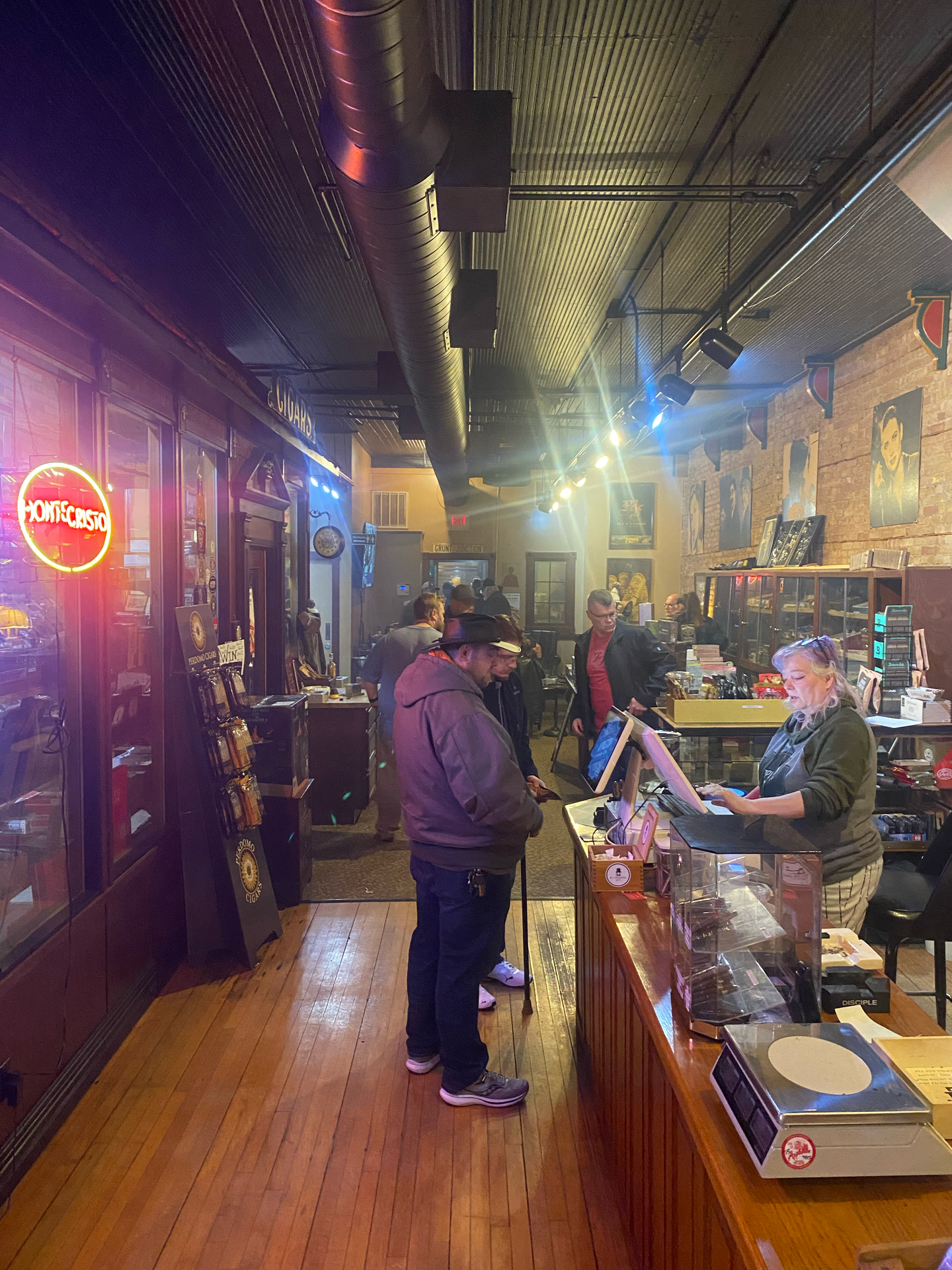 A group of people are standing in a store with a pepsi sign in the background.