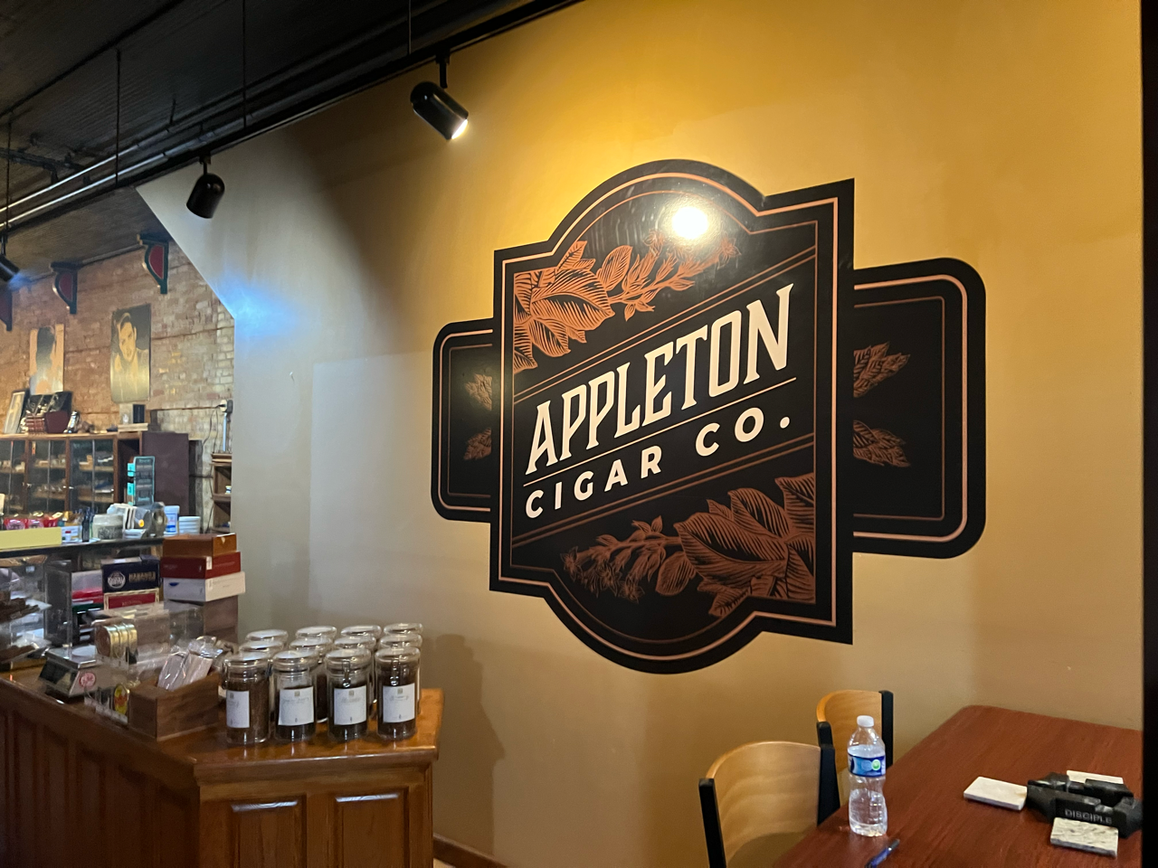 Large photo of the Appleton Cigar Co logo on a wall.