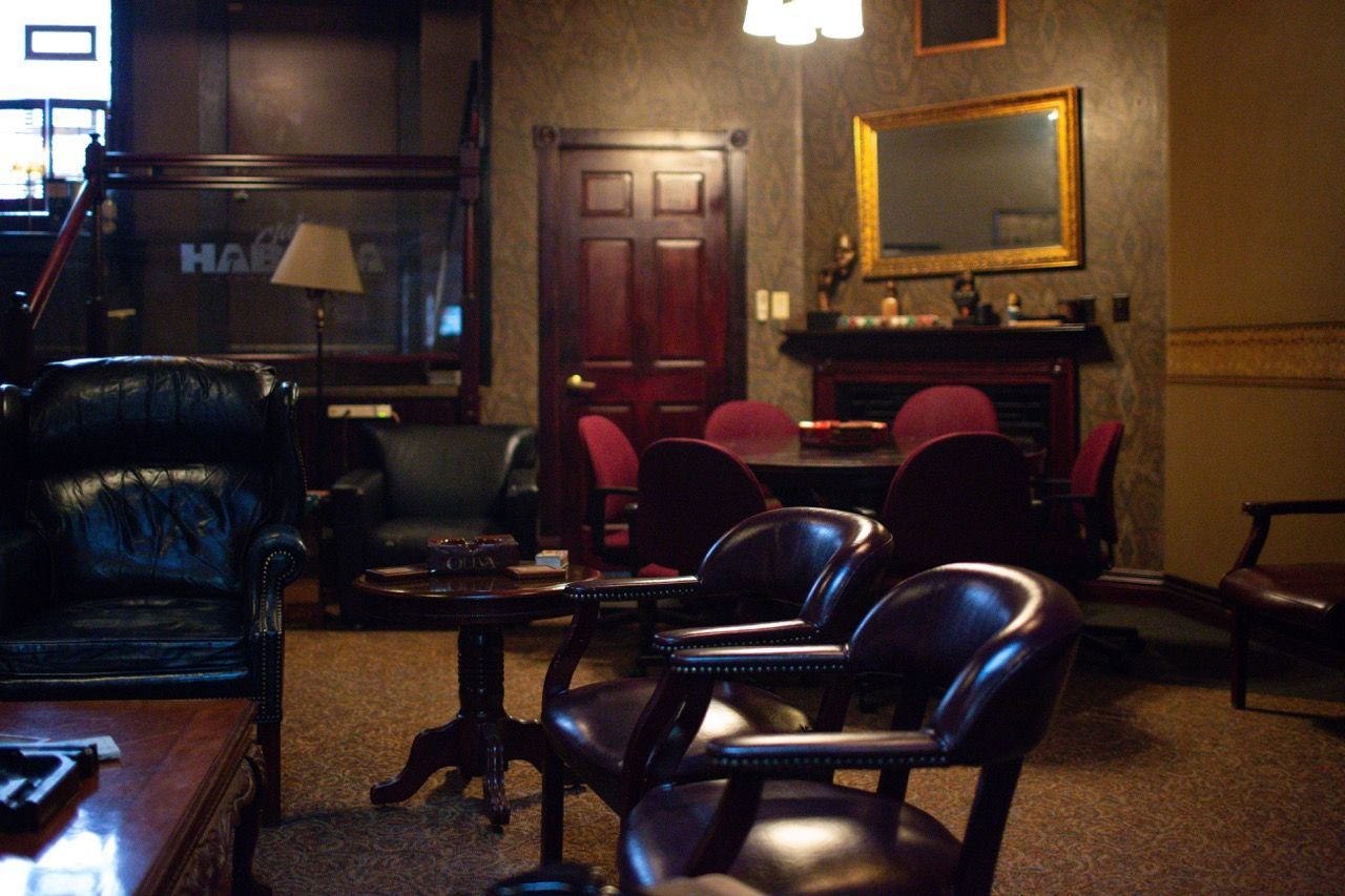 A cigar lounge with a fireplace and a sign that says harp