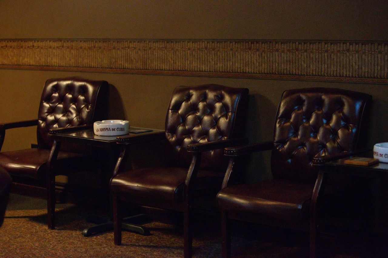 A row of chairs and a table with an ashtray on it