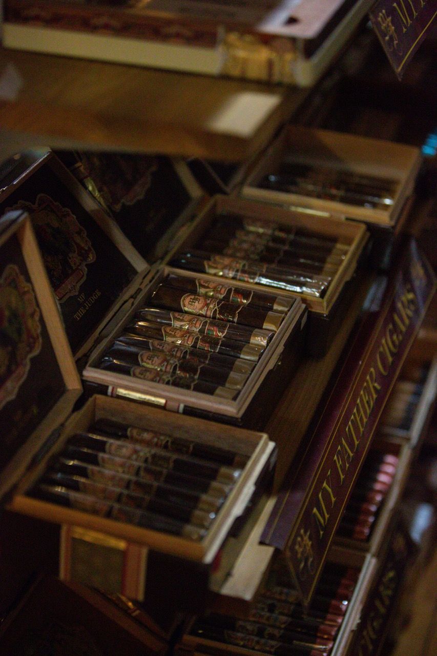 A shelf filled with boxes of cigars and a sign that says `` my father 's cigars ''.