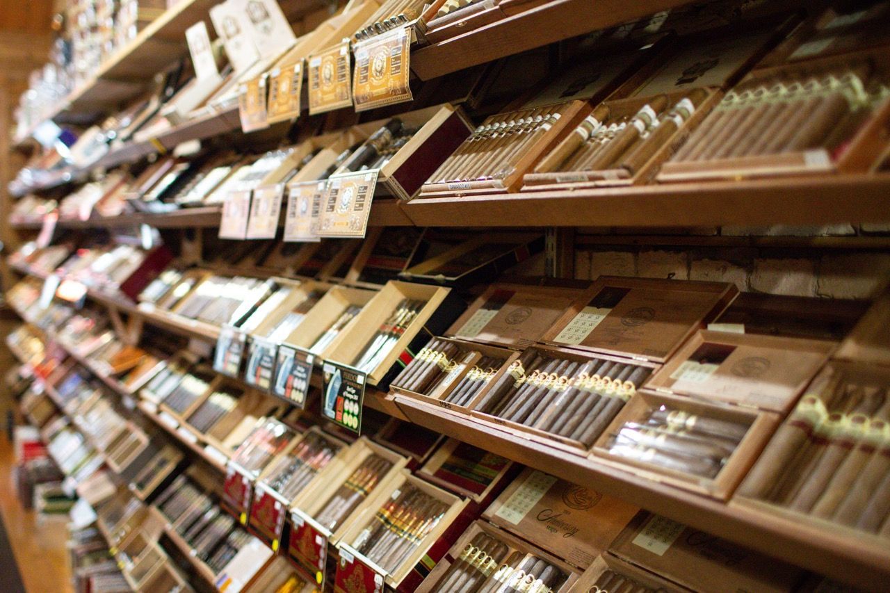 A shelf filled with boxes of cigars in a store.