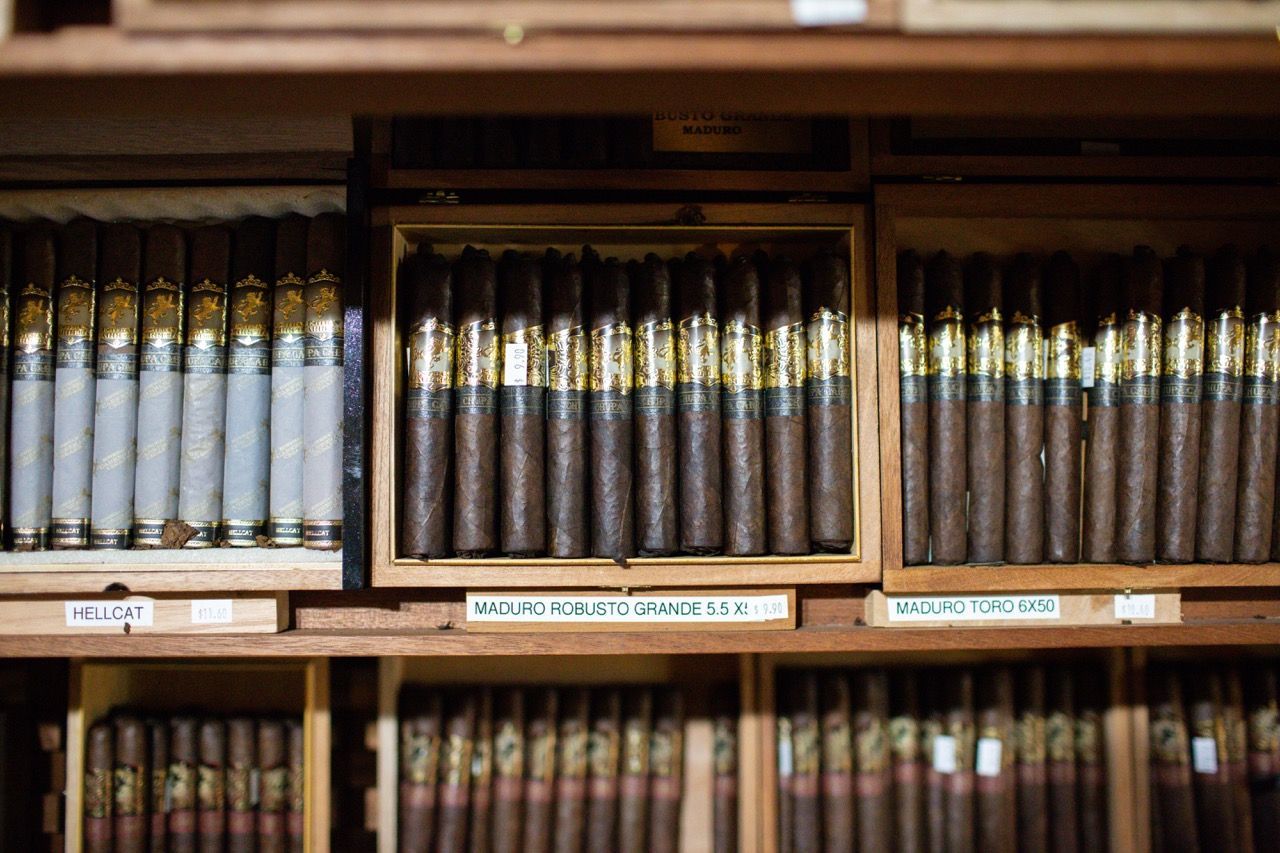A shelf filled with lots of cigars in wooden boxes