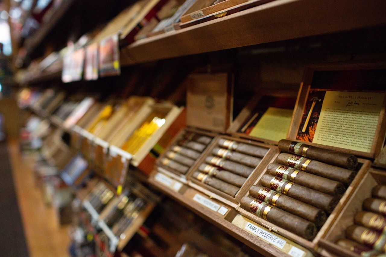 A shelf filled with boxes of cigars in a store.