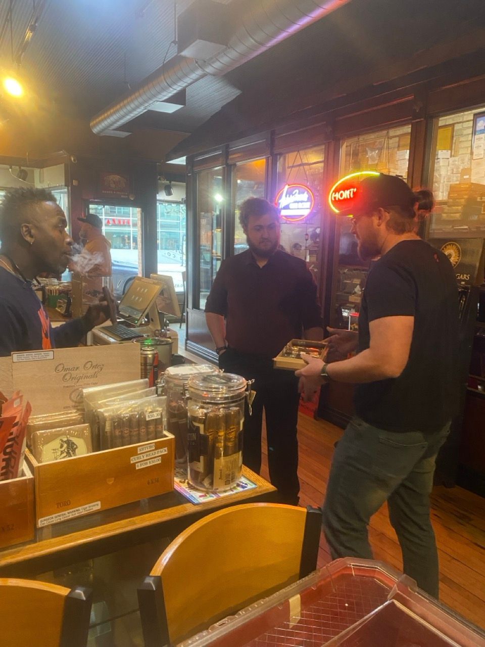 A group of men are standing around a table in a restaurant.