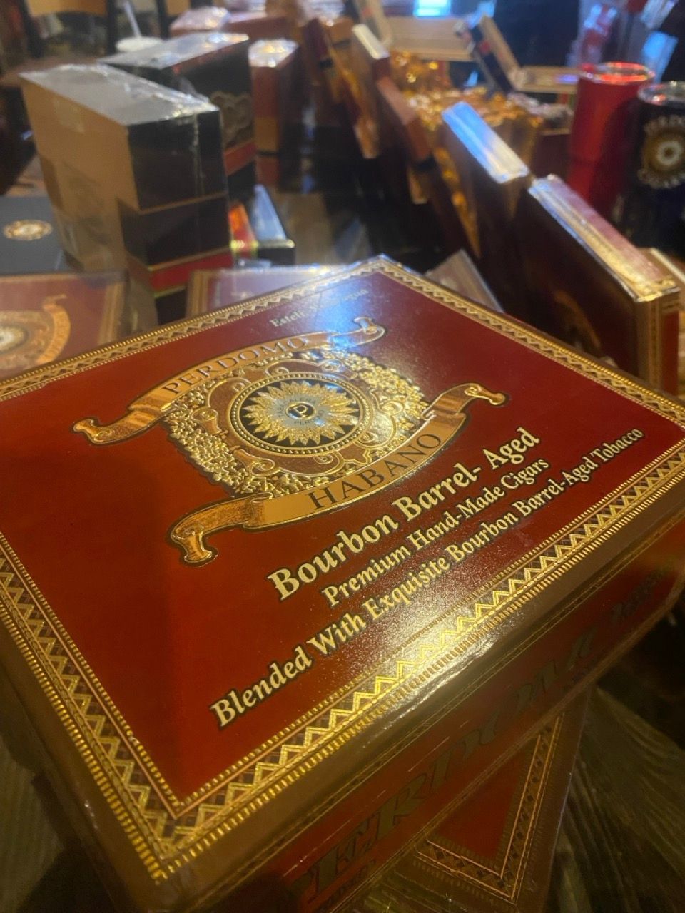 A box of bourbon barrel aged cigars is sitting on a table.