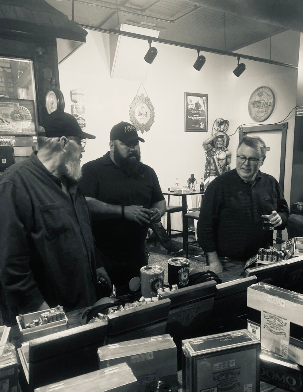 A group of men are standing around a counter in a restaurant
