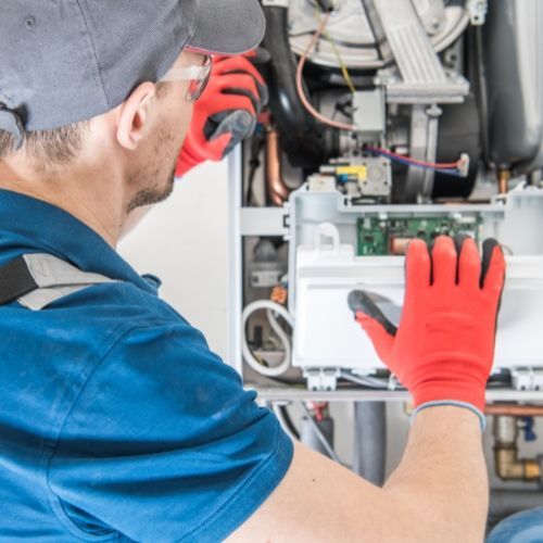 A man wearing red gloves is working on a machine