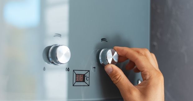 A person is adjusting a knob on a stove.
