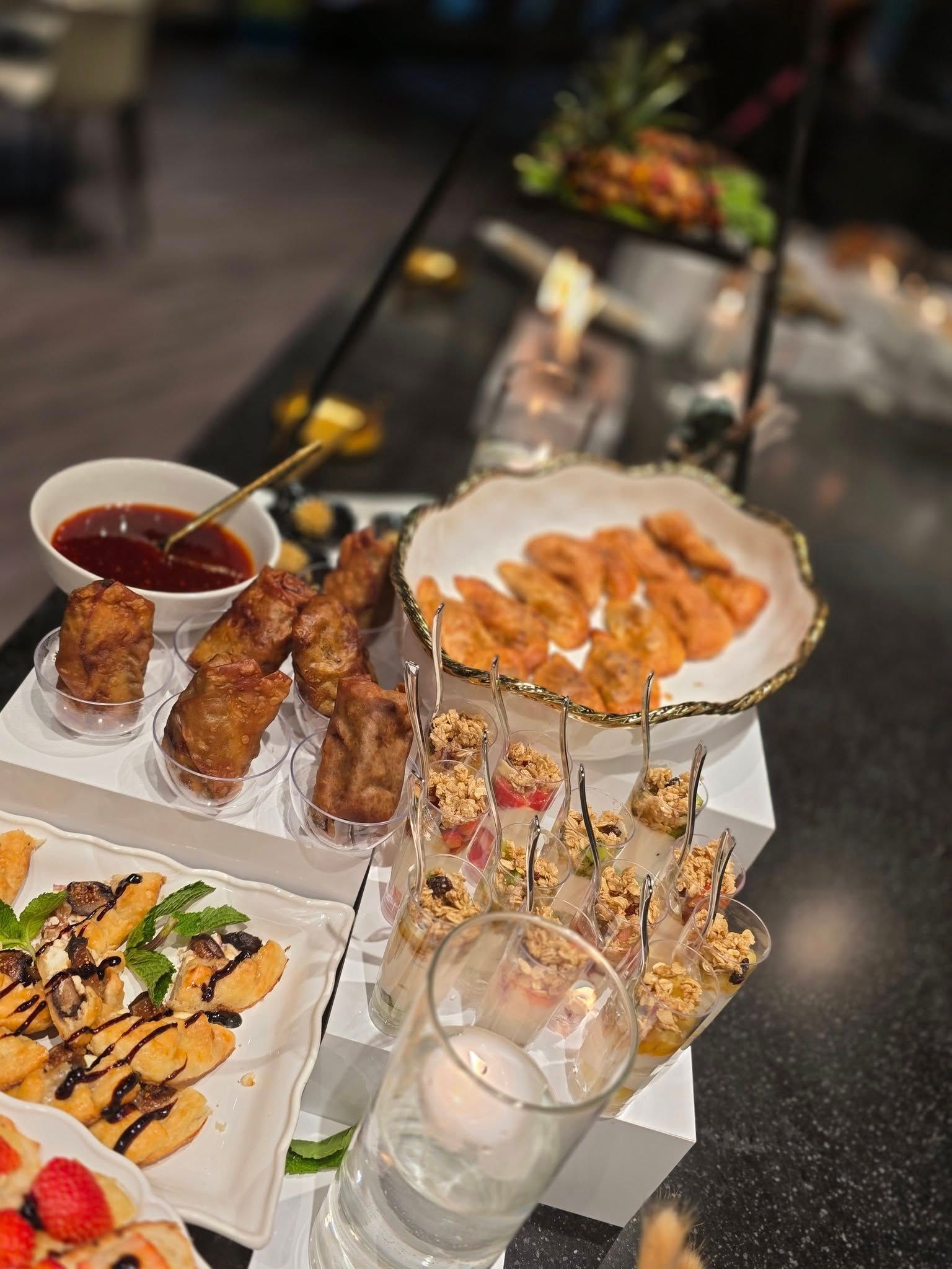 Dim sum platter with skewers, shrimp, dumplings, and dipping sauce on a restaurant table