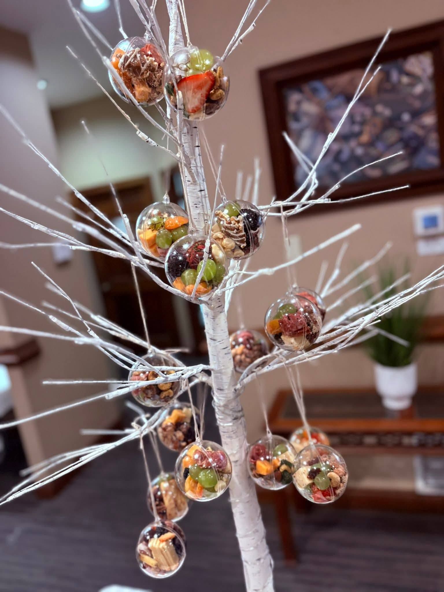 Decorative silver tree with hanging glass ornaments in warm autumn colors indoors