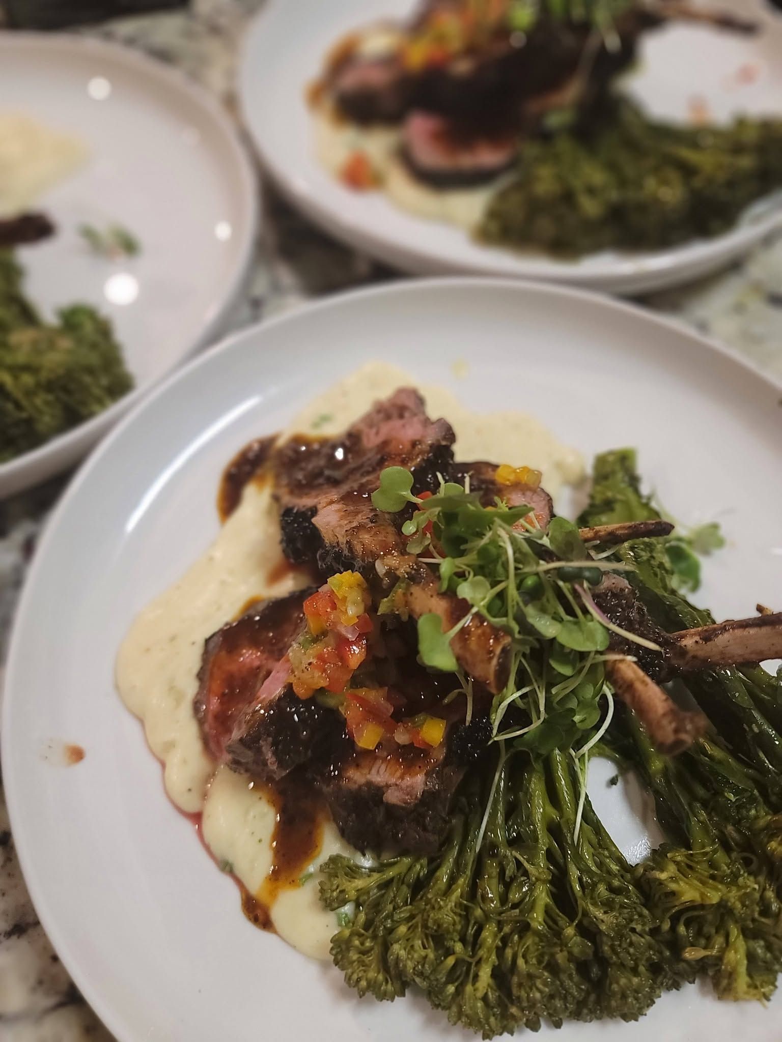 Plated gourmet steak with broccoli and garnish on a white dinner plate