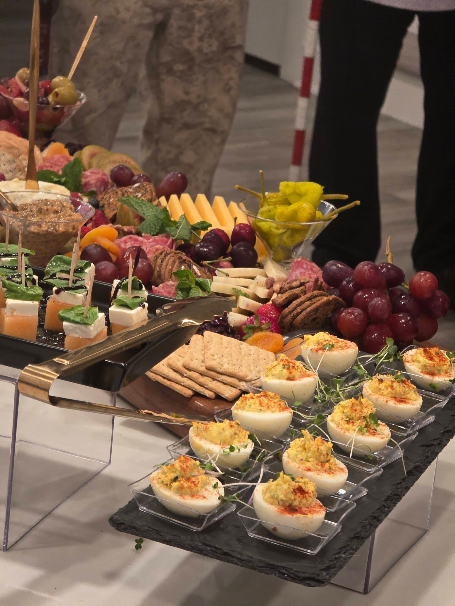 Elegant appetizer platters with assorted finger foods, fruit, and pastries arranged on a buffet table