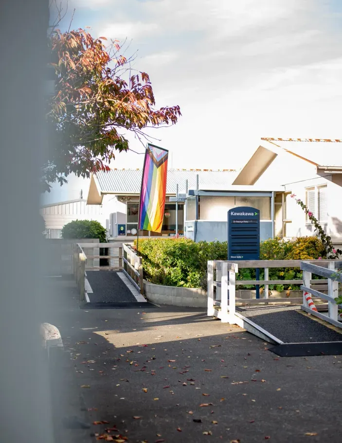 The approach path and ramps to the medical centre buildings in Tamatea, with a progress pride flag flying beside the entrance