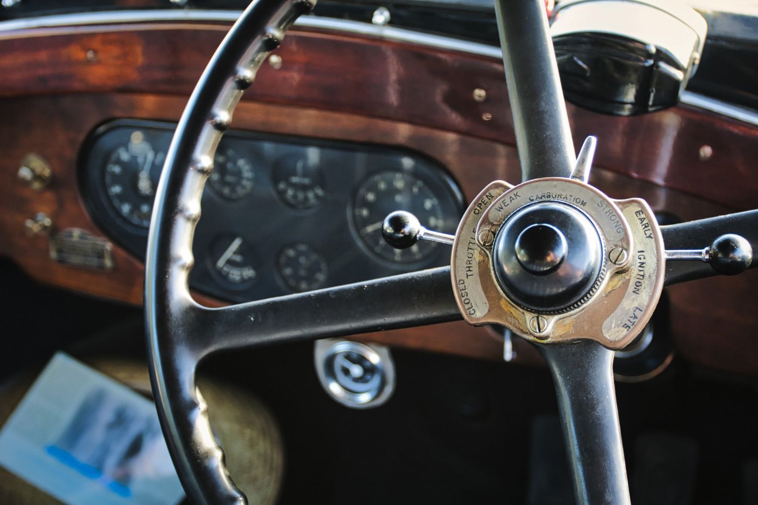 Classic car steering wheel and dashboard with wood trim and gauges