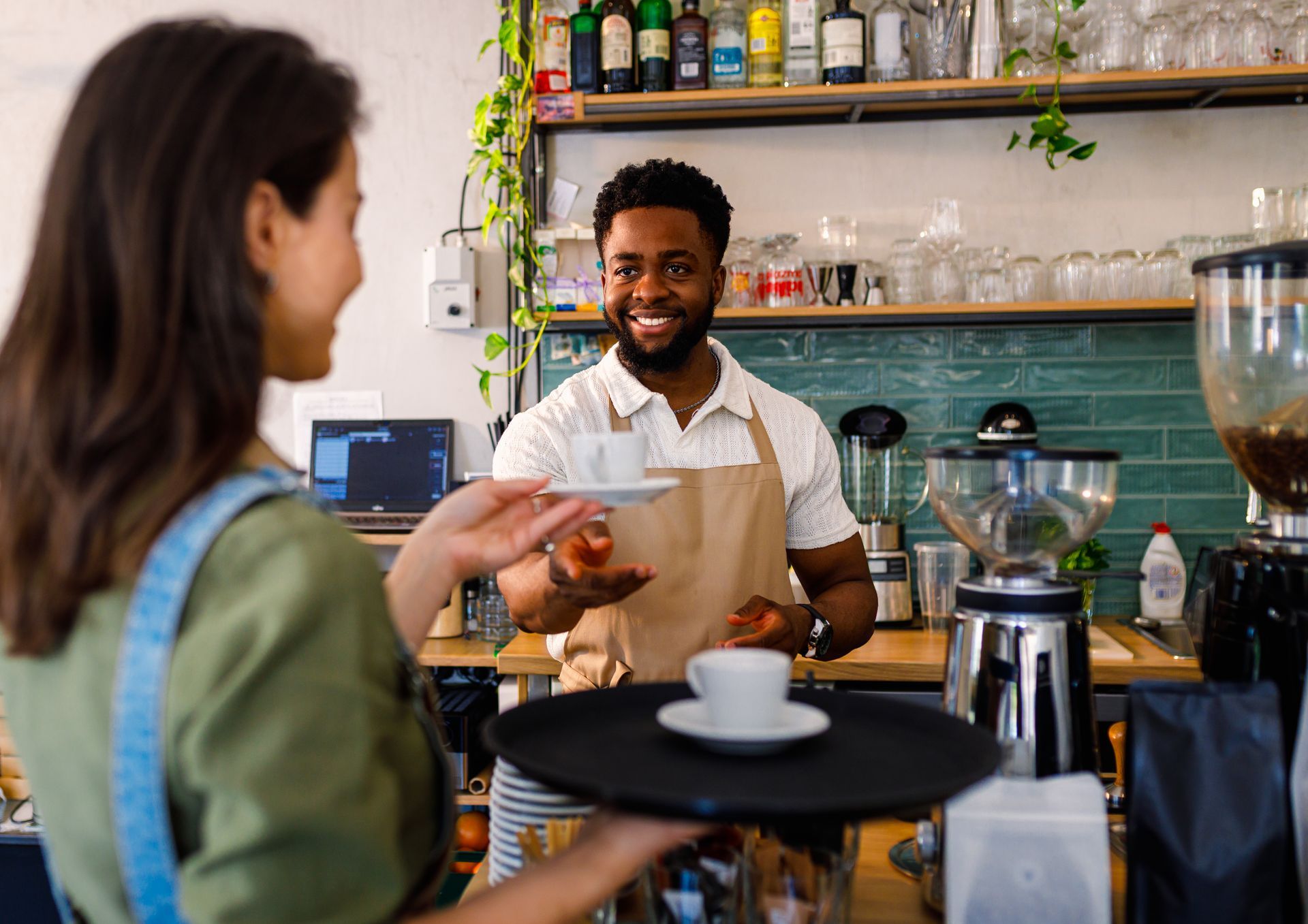 Cafe barista smiling while serving a customer at the counter