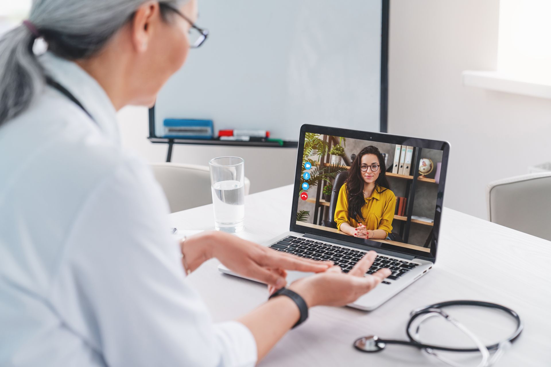Doctor on video call with patient using a laptop in a bright clinic office