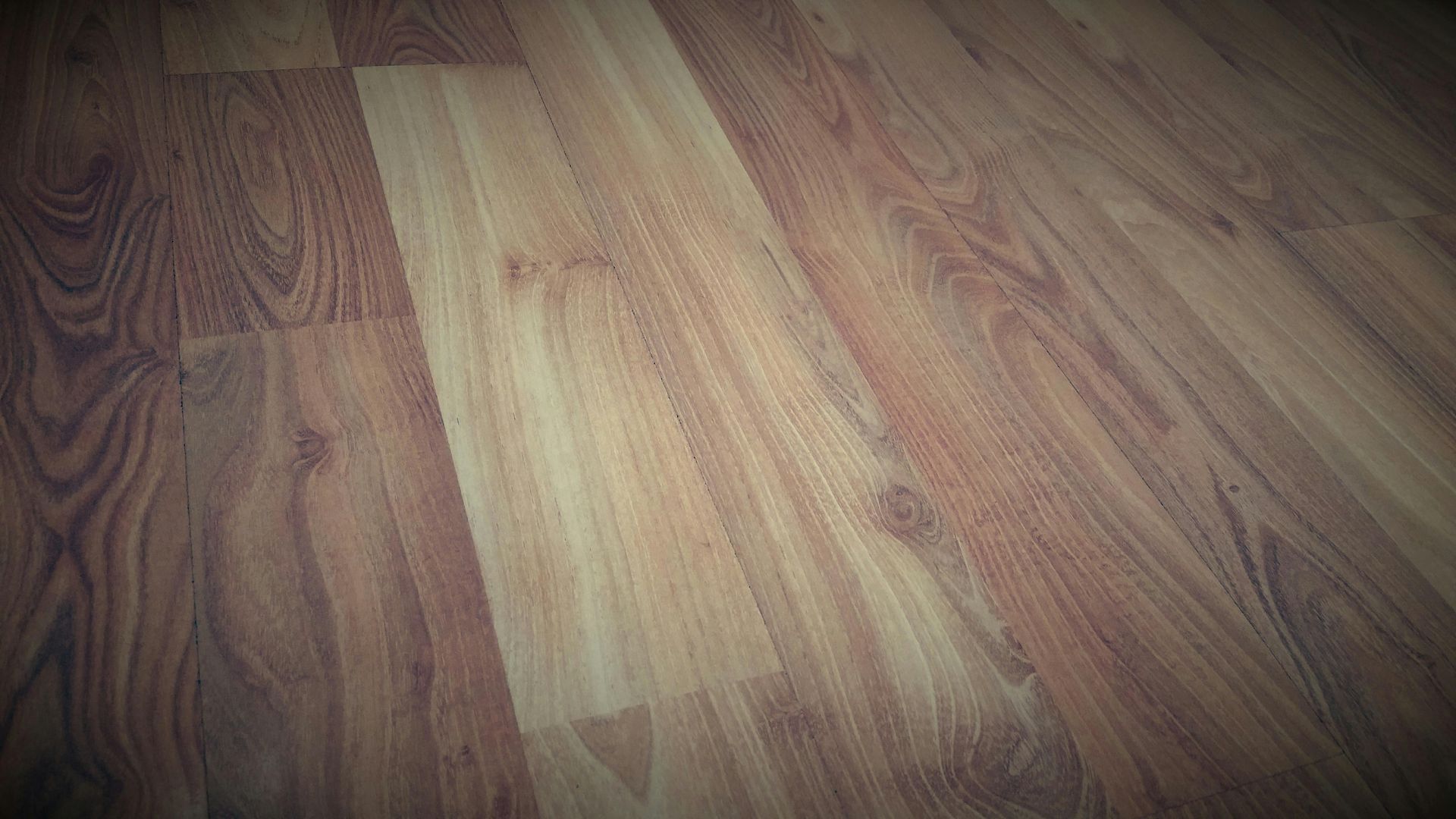 Wooden flooring with various shades of brown.