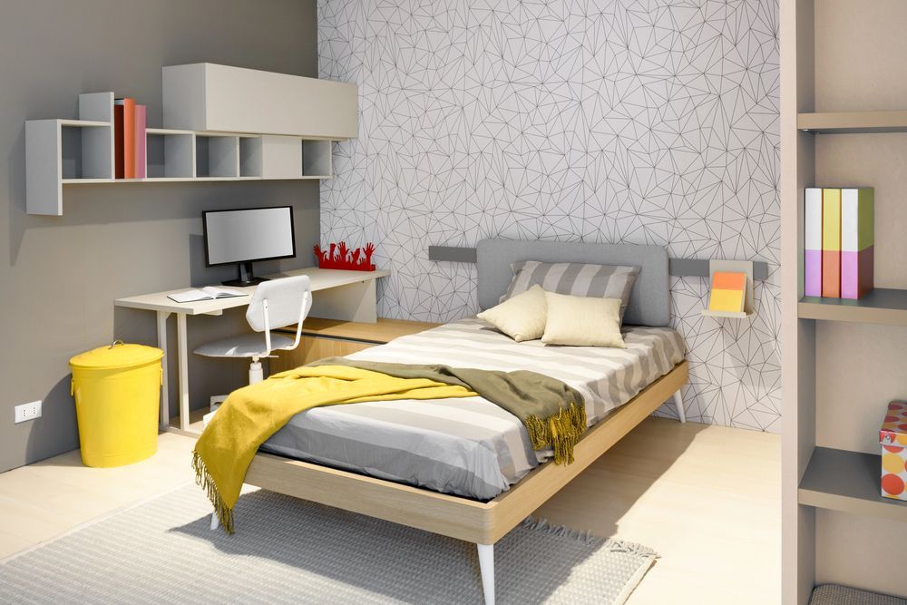 Camera da letto moderna con letto singolo, scrivania, mensole e dettagli gialli.