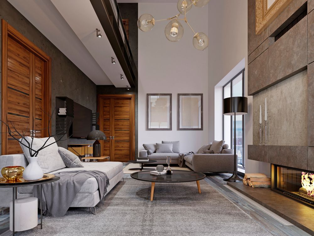 Soggiorno moderno con divano angolare grigio, camino, porte in legno e ampie finestre.