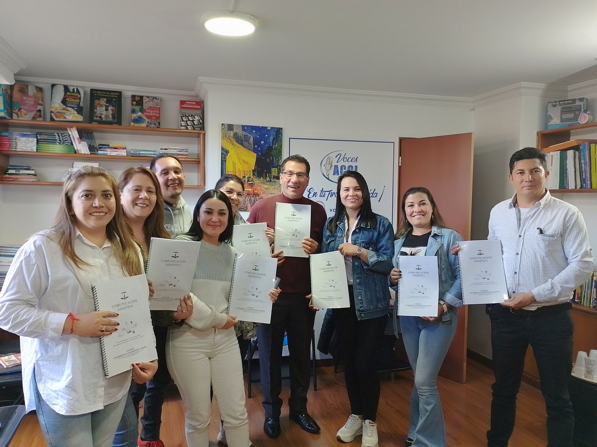 Grupo de personas sosteniendo certificados, sonriendo en un entorno de oficina.