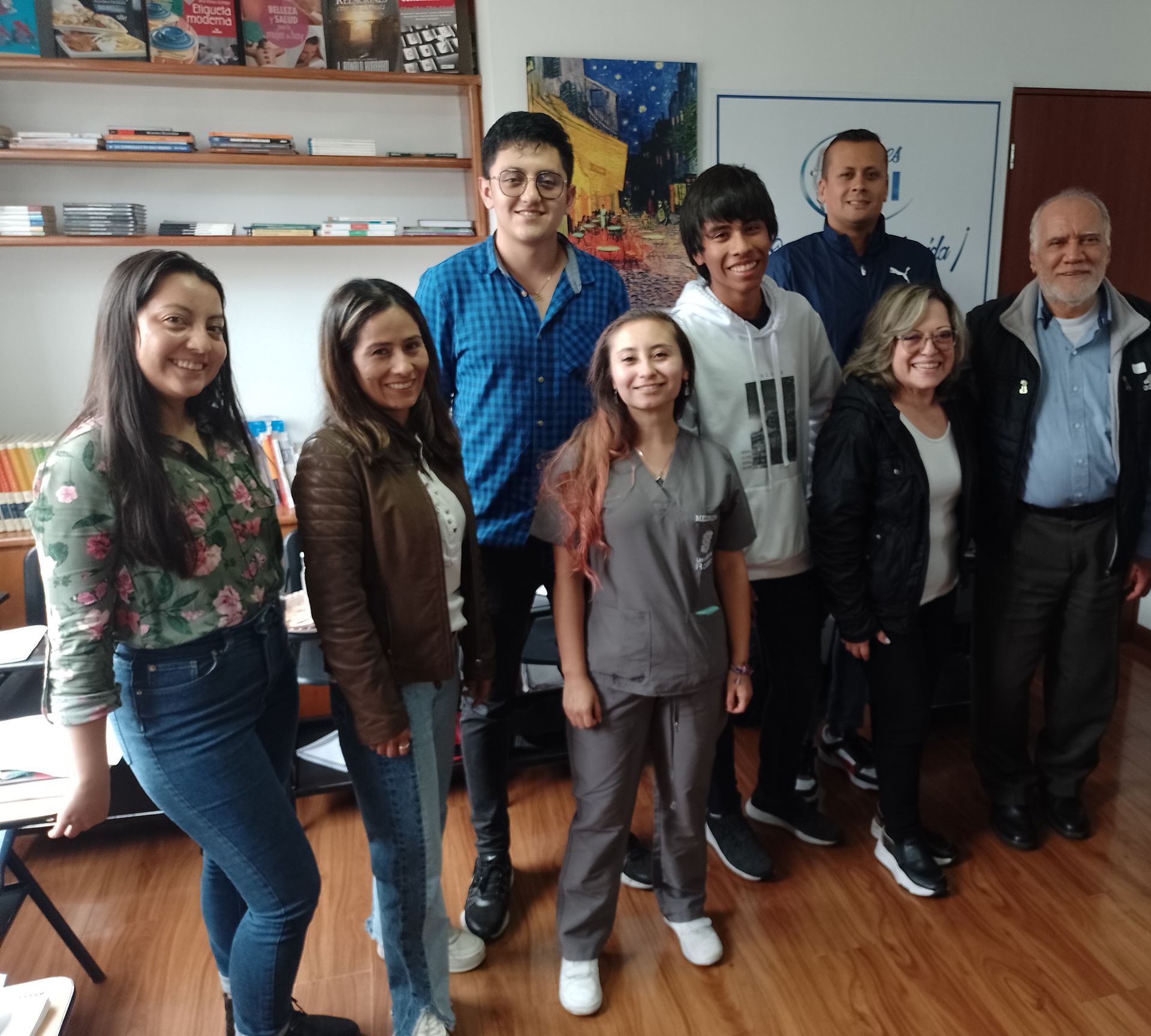 Grupo de personas posando juntas en el interior, sonriendo.