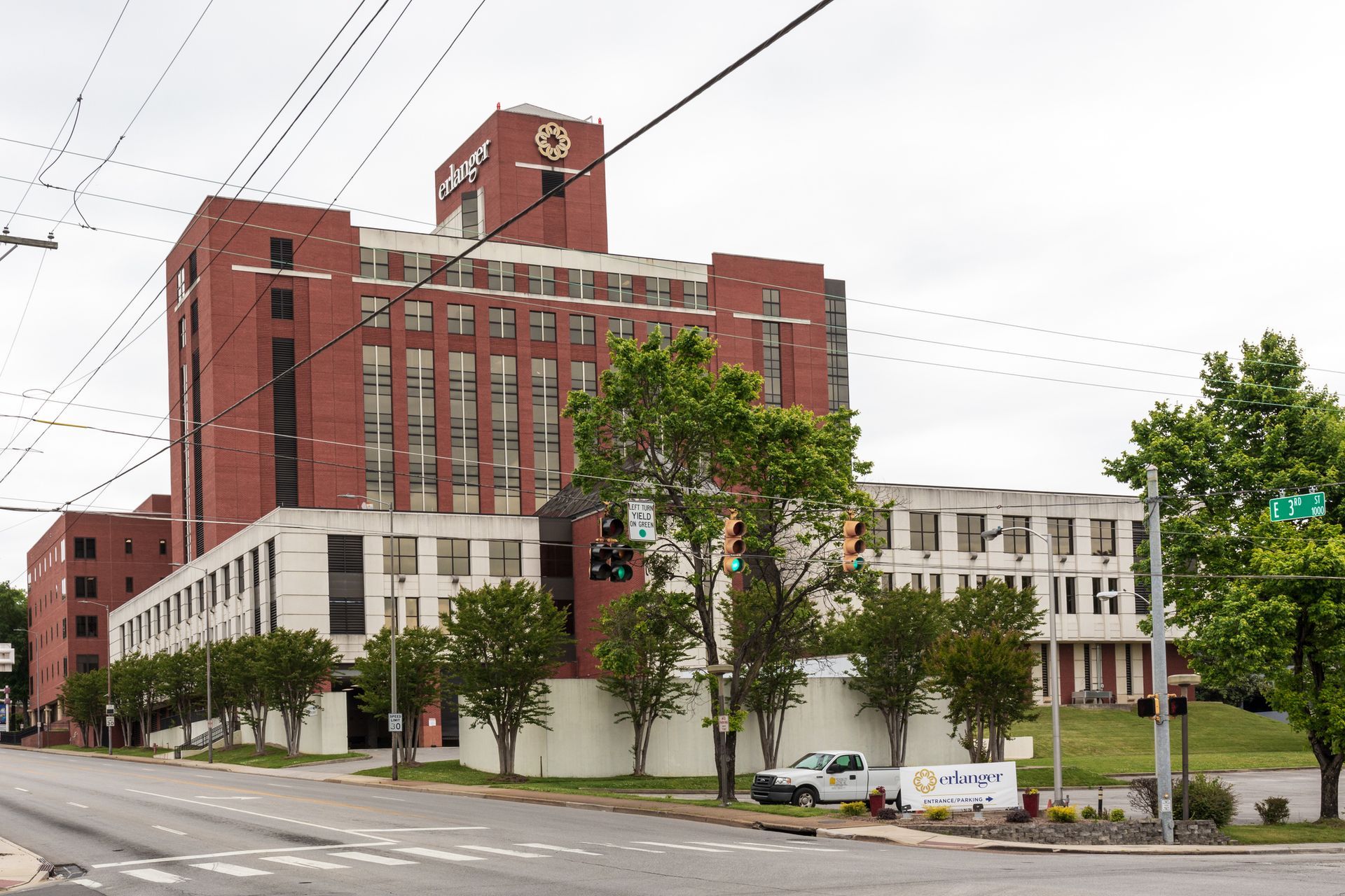 A large brick building is sitting on the corner of a street.