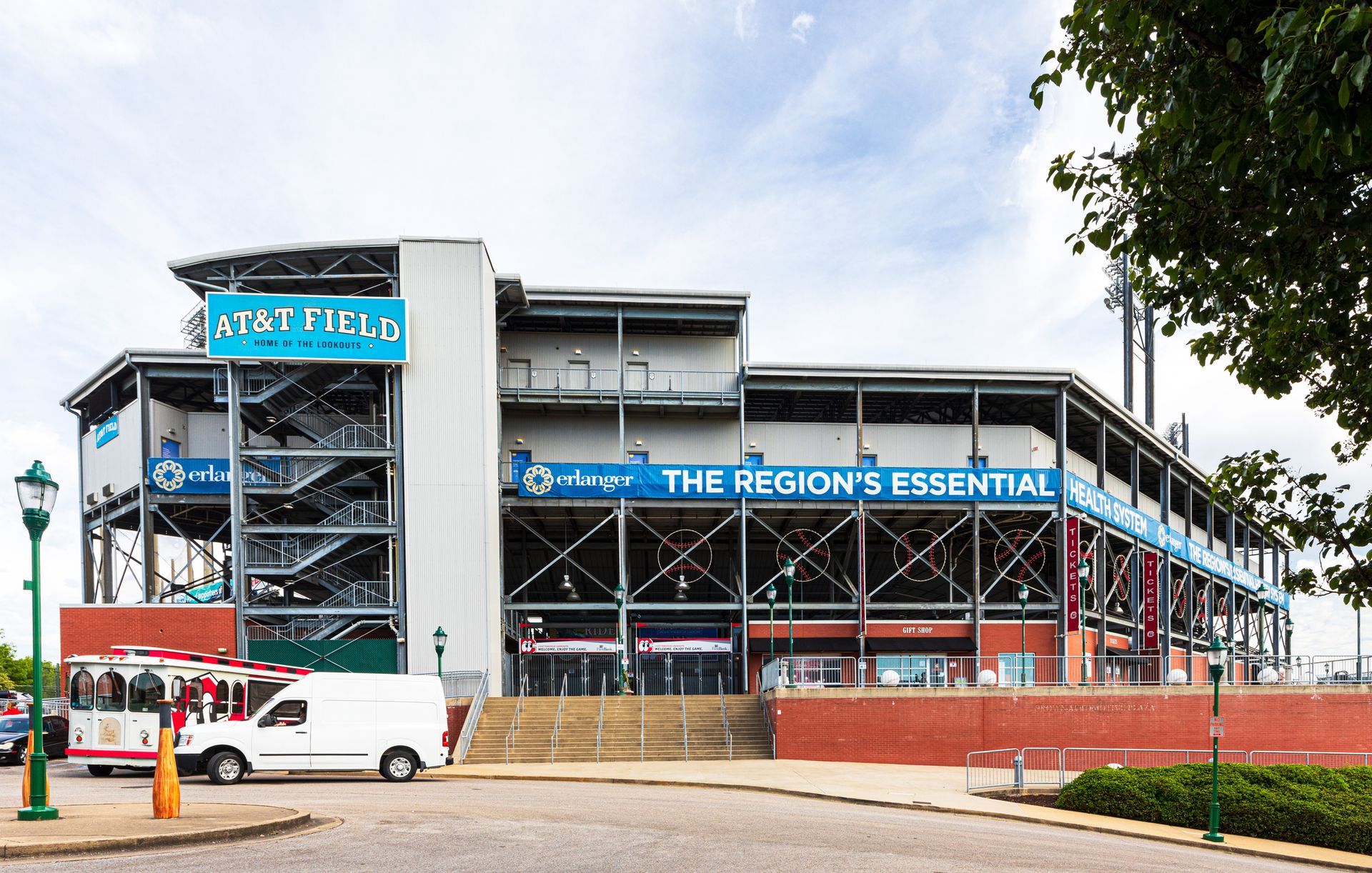 A white van is parked in front of a building that says the region 's essential
