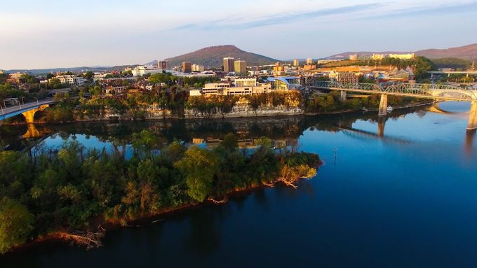 An aerial view of a city surrounded by water and trees.