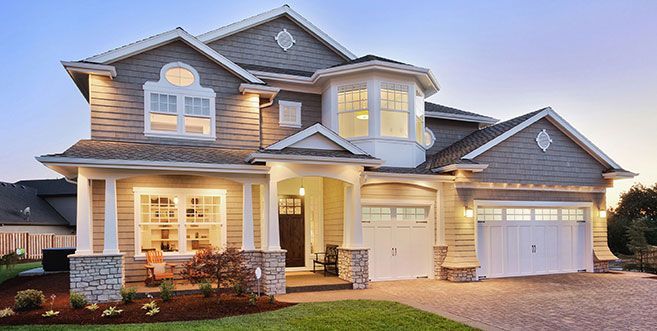 A large house with a lot of windows is lit up at night.