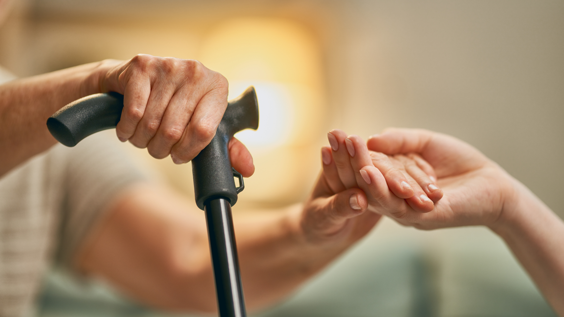 Nurse pointing, arm around elderly woman in bathrobe; indoors, cheerful expressions.