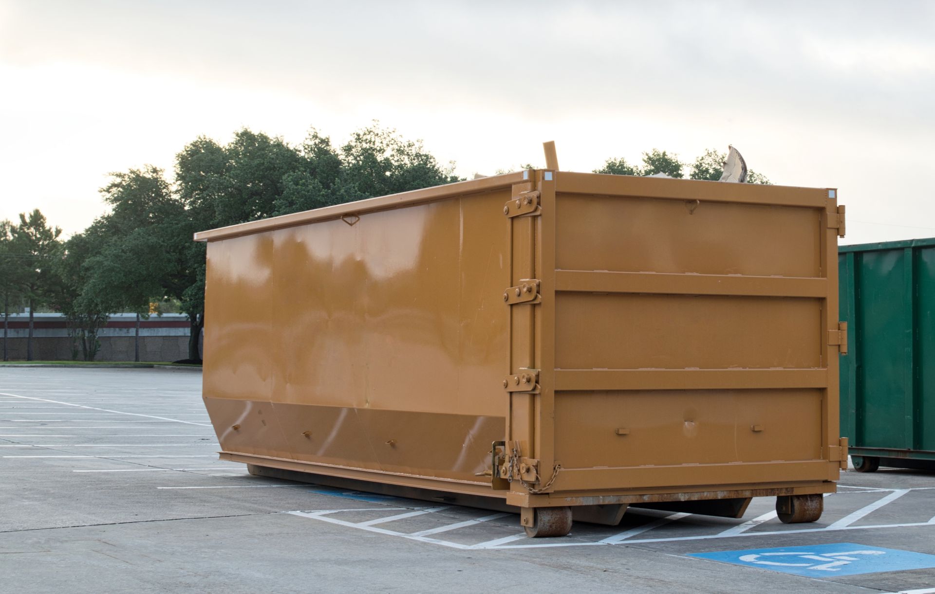 Dumpster rental industrial bin in commercial parking lot. Dumpster rental industrial bin in commercial parking lot.