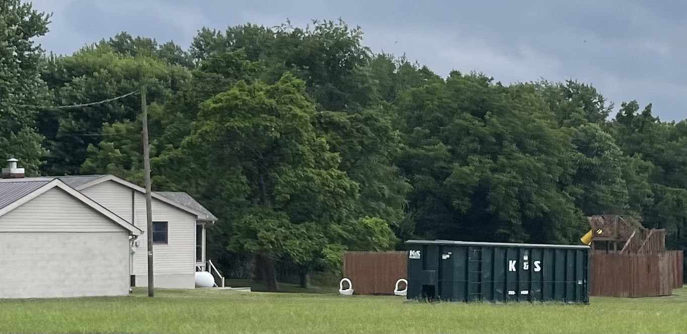 A white house is sitting in the middle of a grassy field.