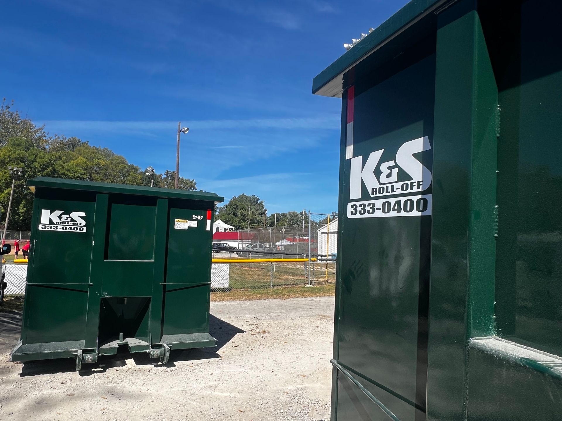 A green dumpster with the word kes painted on it