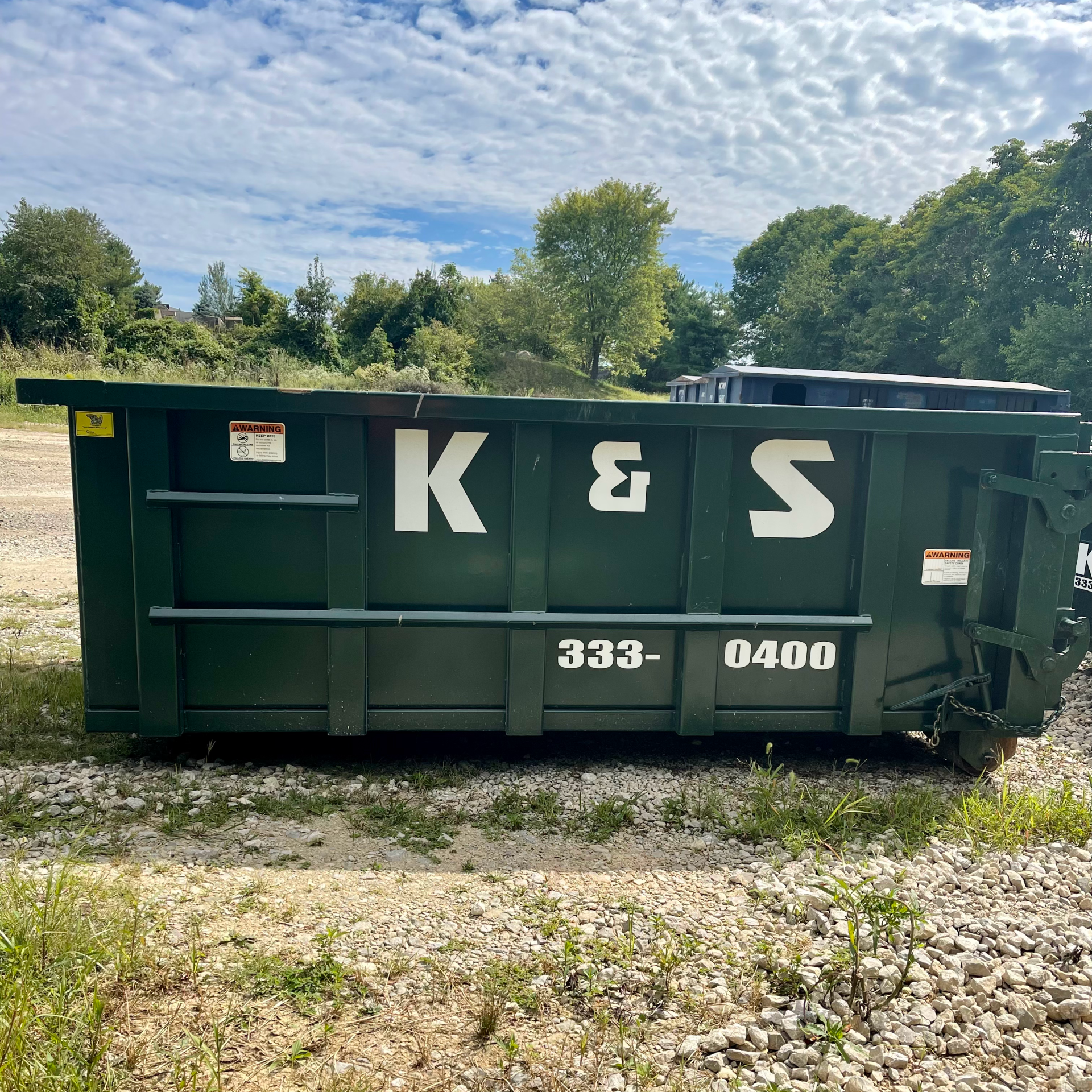 A dumpster with the letters k & s on it