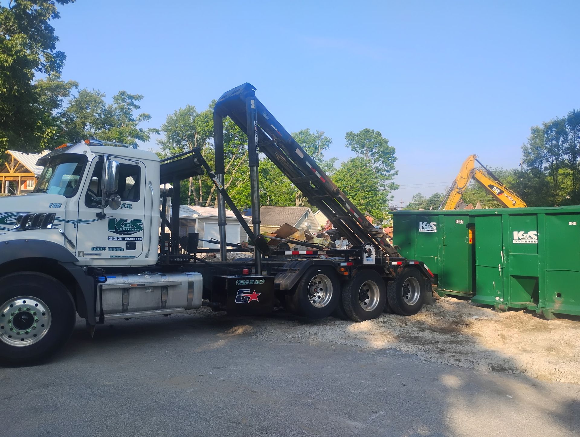 A large green dumpster is parked in front of a store called a center