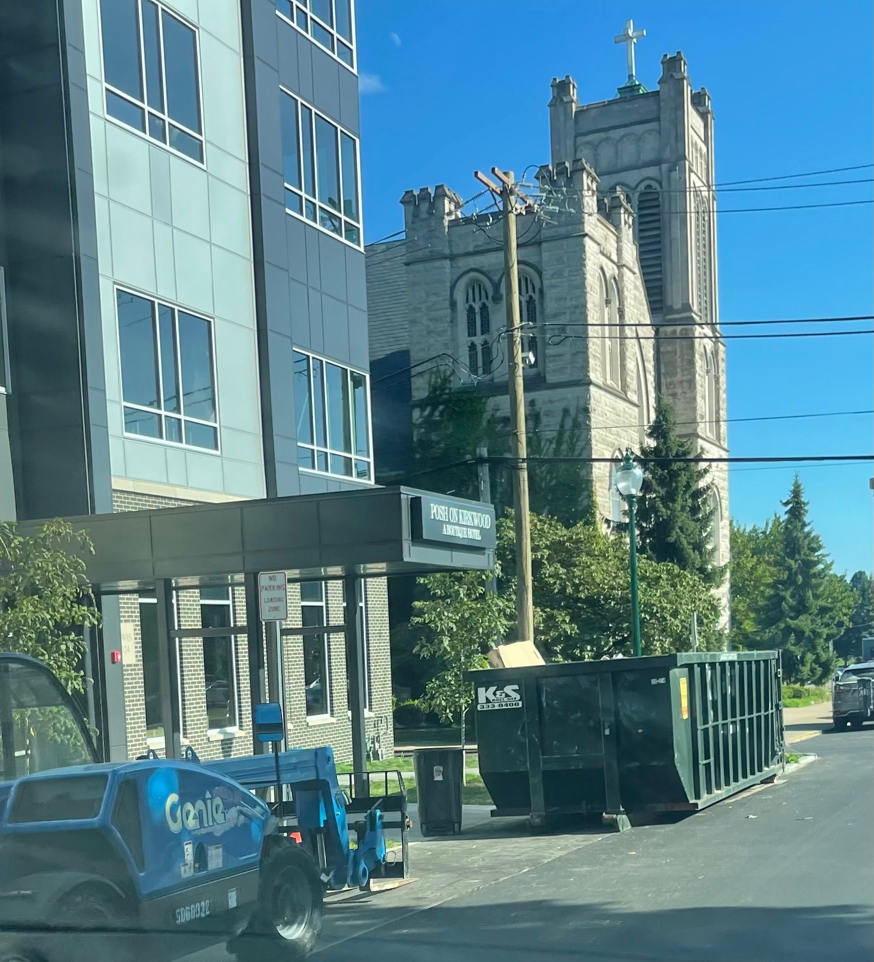 A large green dumpster is parked in front of a store called a center