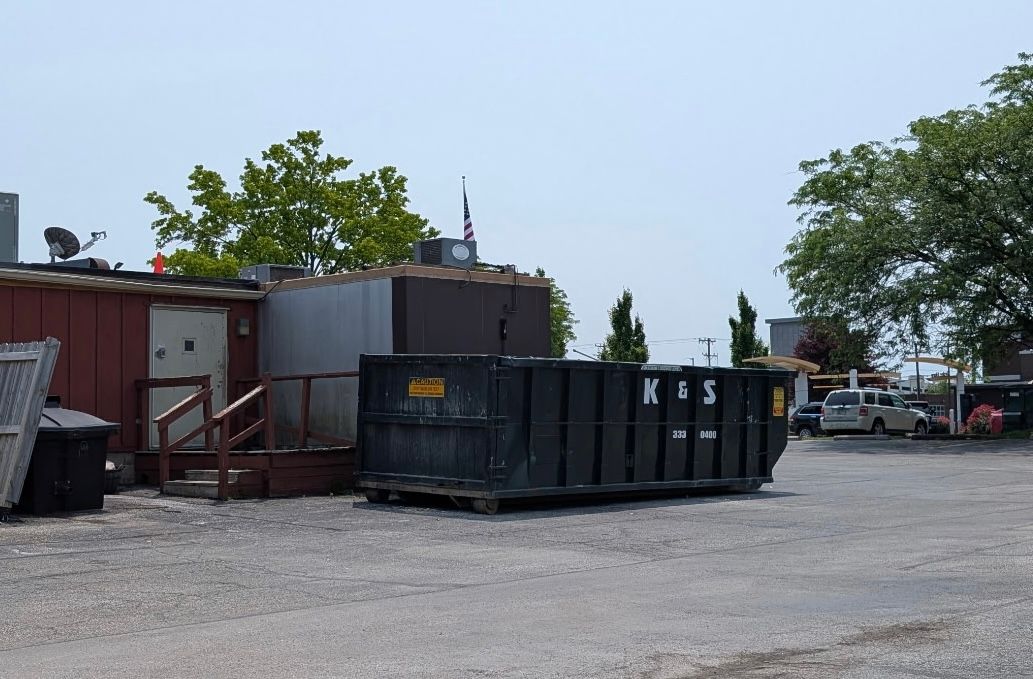 Roll-off dumpster from K & S Rolloff in Trafalgar, IN, being filled with construction debris