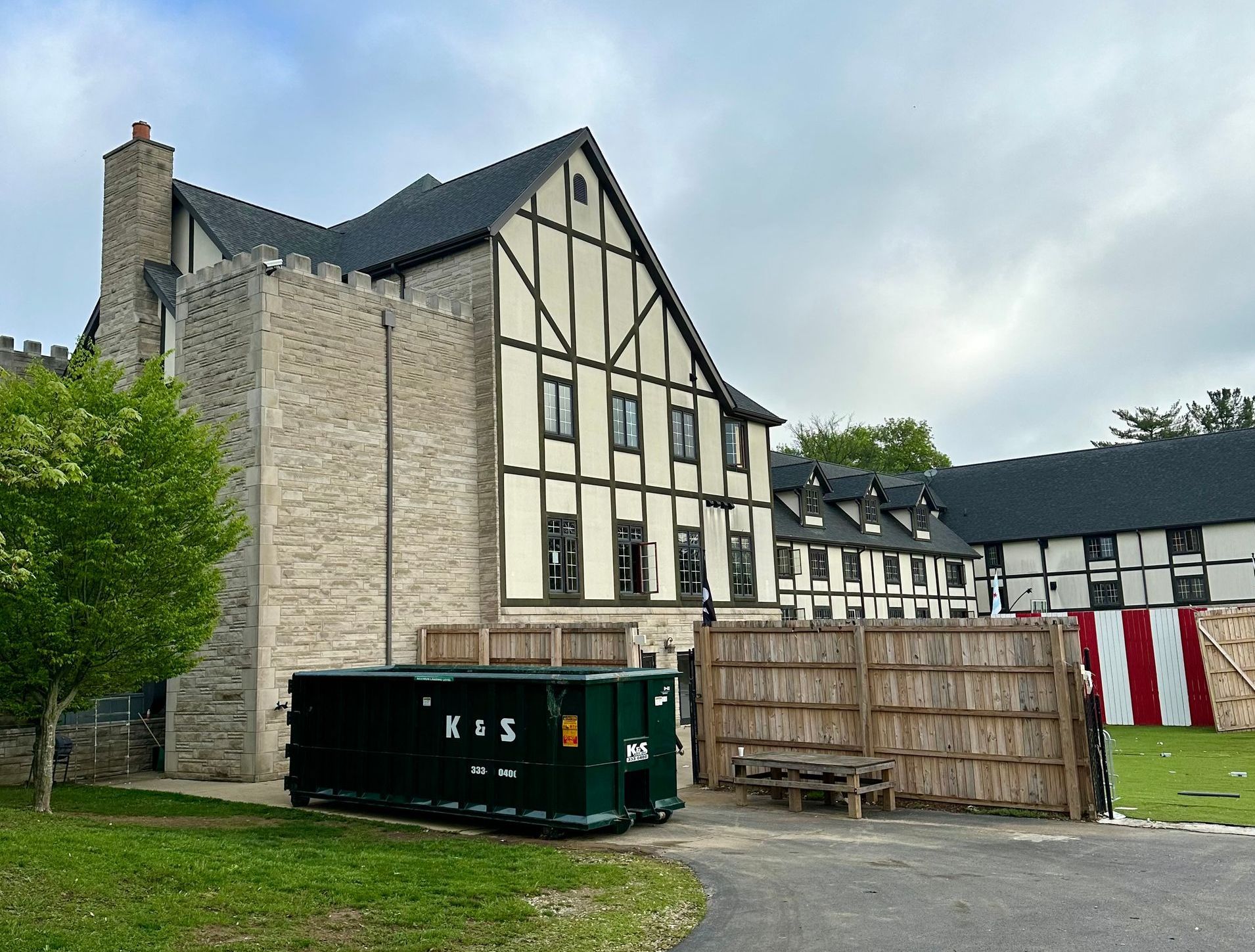 A large building with a green dumpster in front of it.