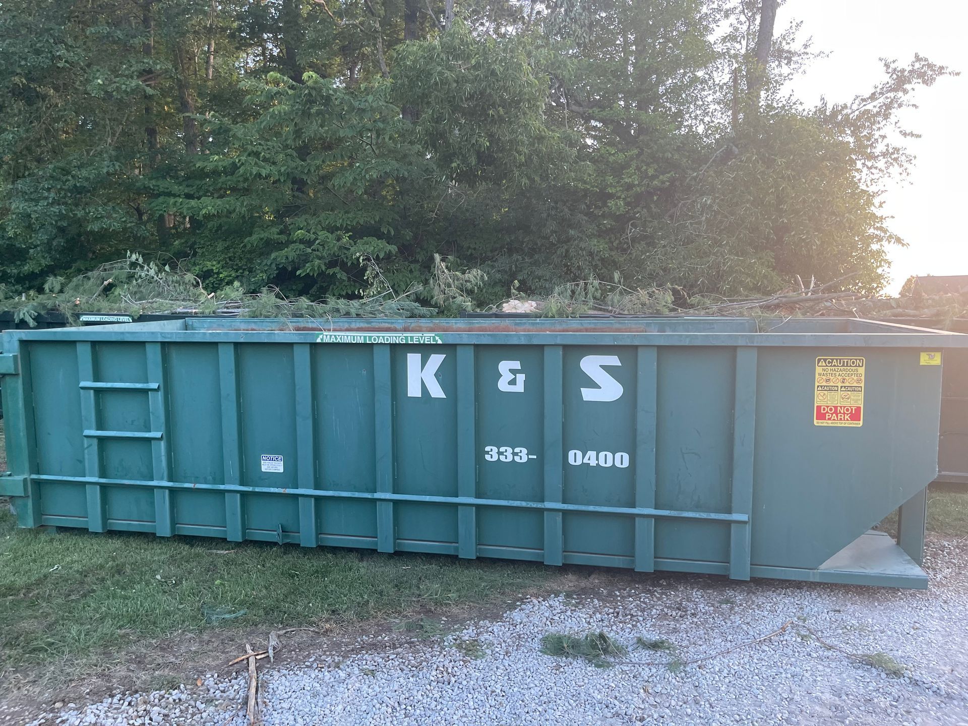 A large green dumpster with the letters k and s on it