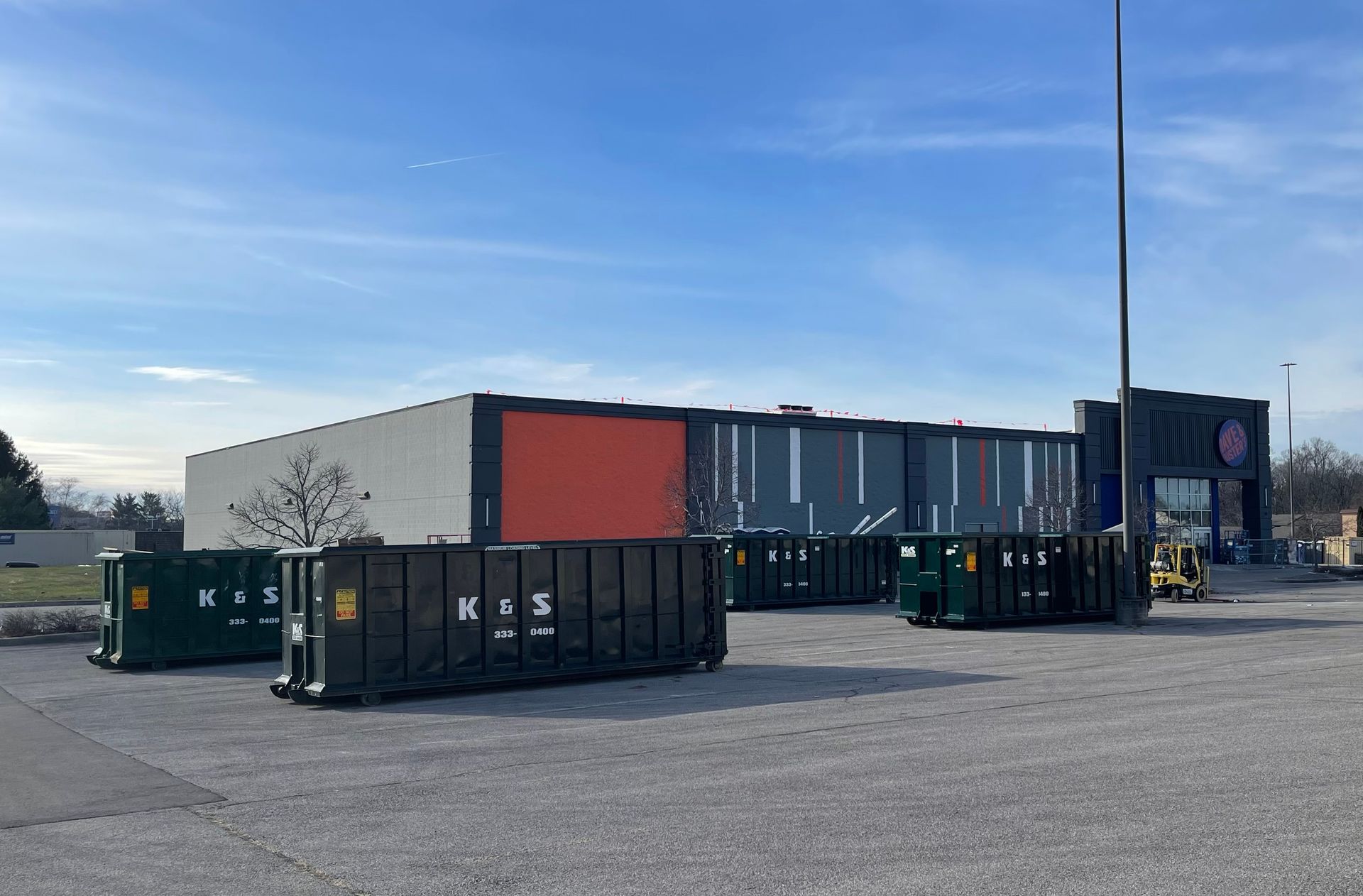 A large building with a lot of dumpsters in front of it.