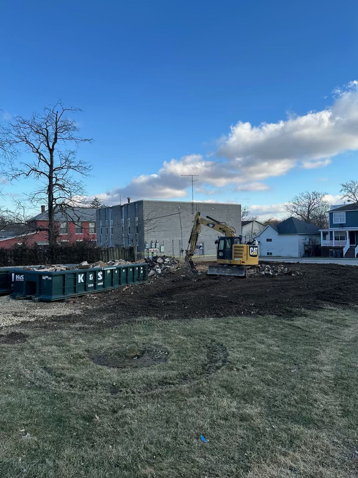 A construction site with a yellow excavator in the middle of it.
