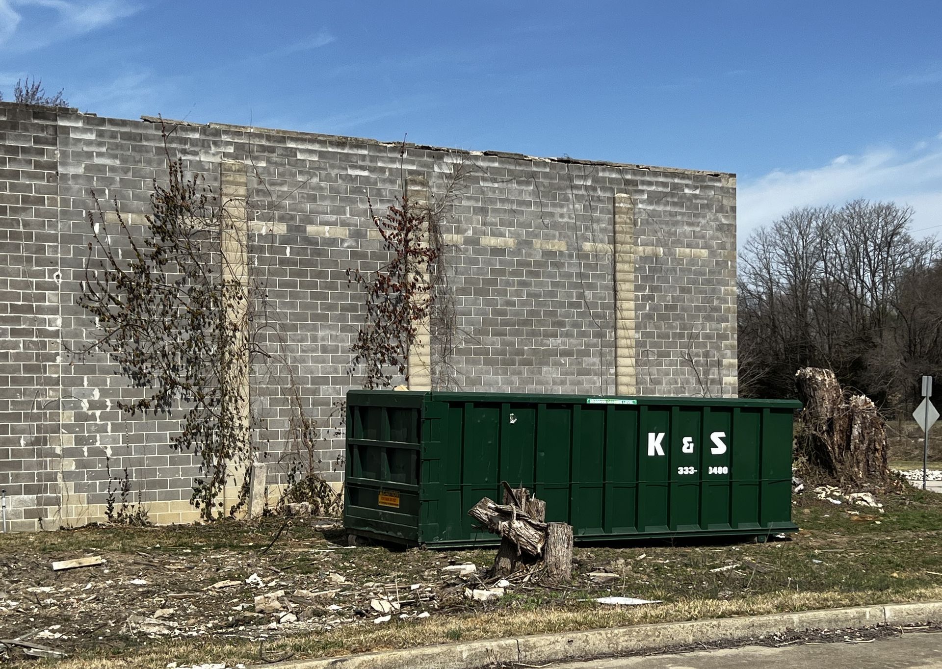 A green dumpster with the letters ks on it