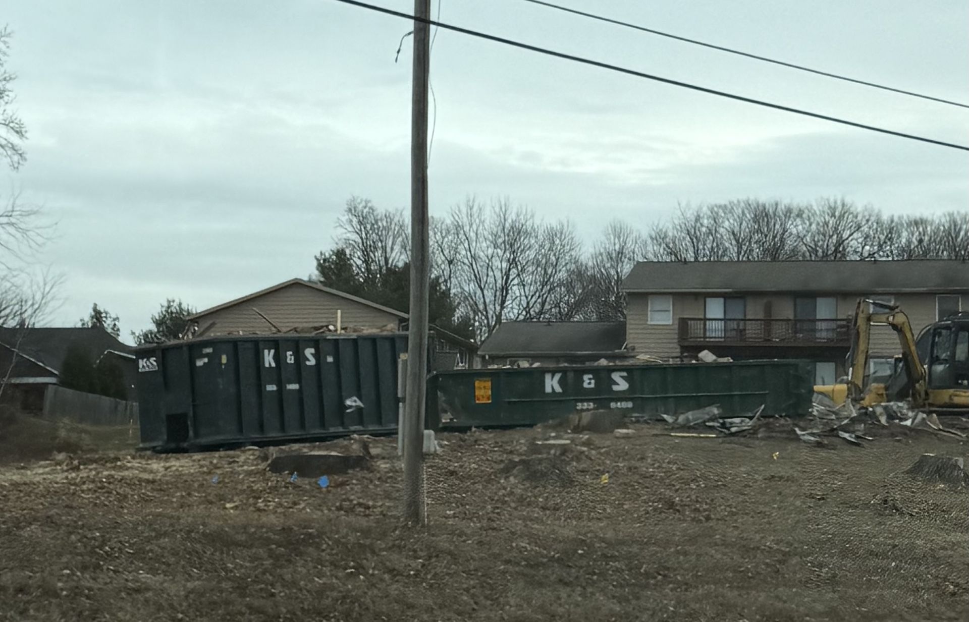 A large green dumpster is parked in front of a store called a center
