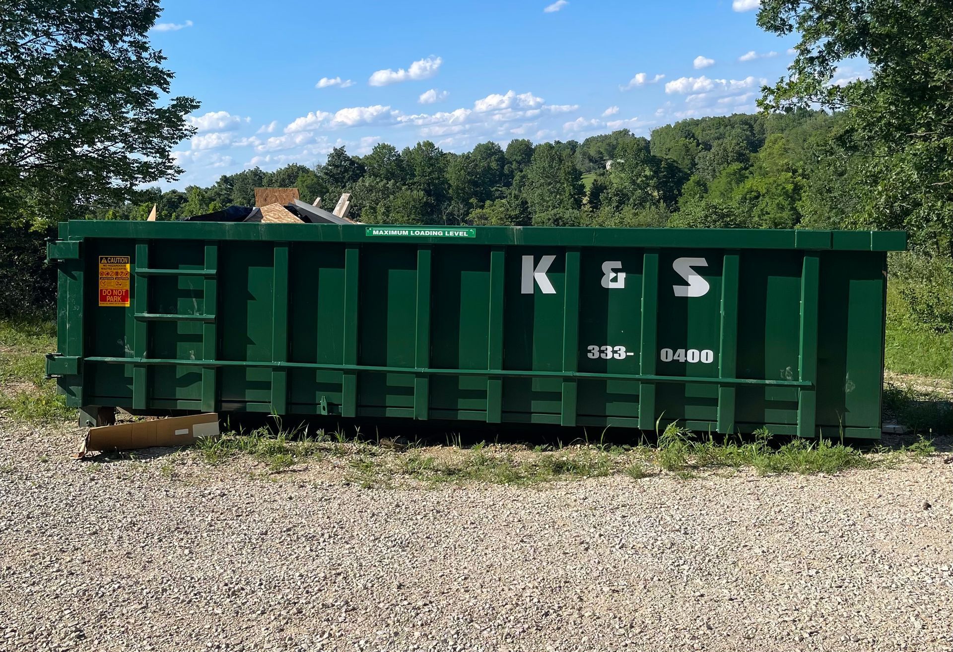 A green dumpster with the letters k & s on it