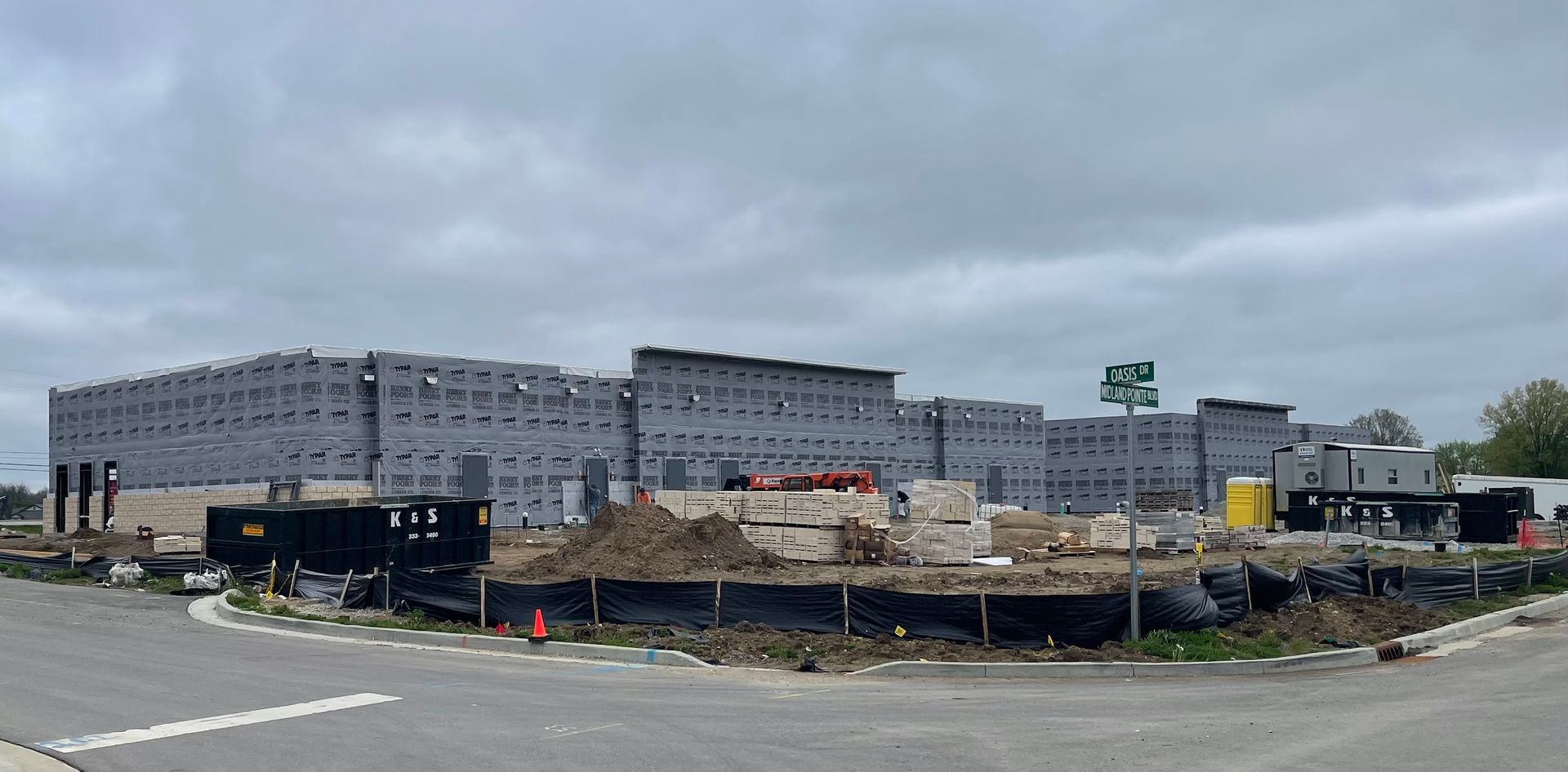 A large building is being built on the side of a road.