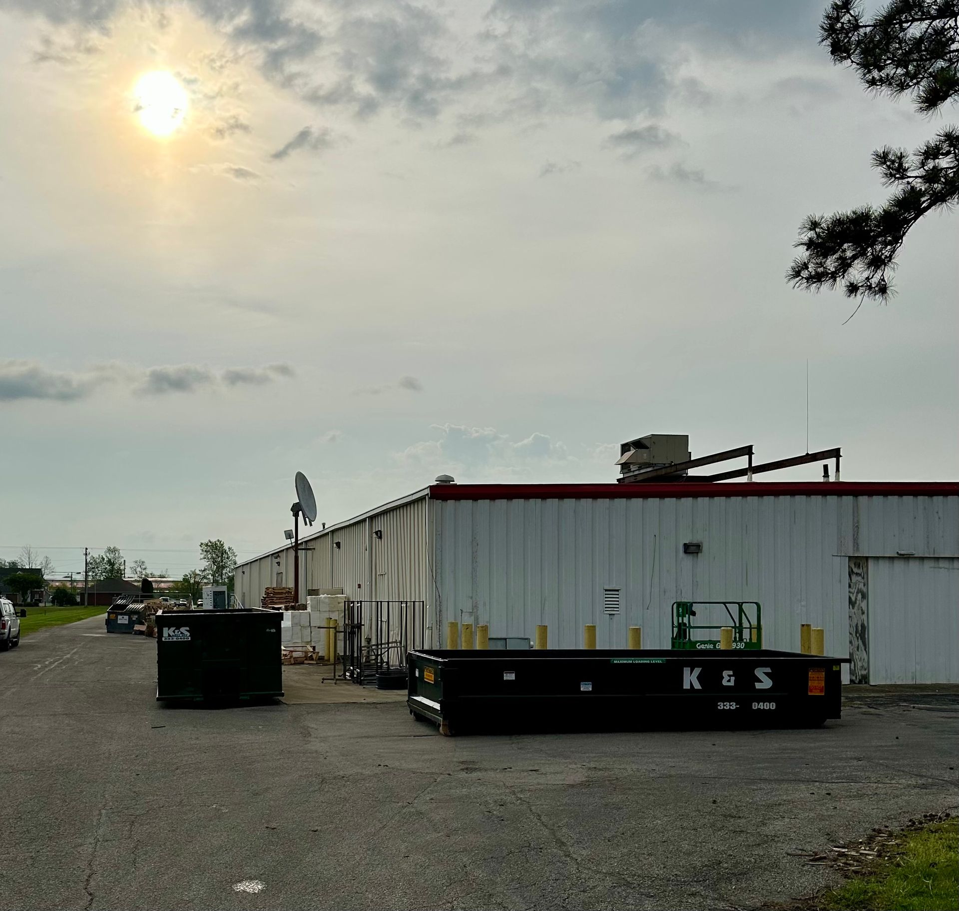 A large building with a dumpster that says kgs on it