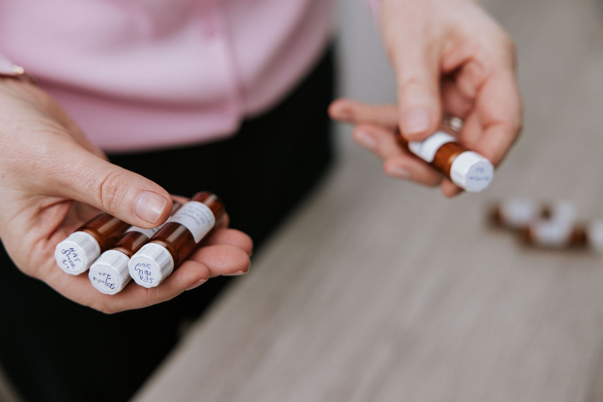 A person is holding a bunch of small bottles in their hands.
